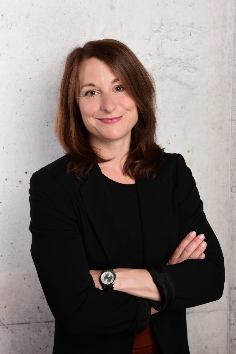 Online Business Managerin Aline Pelzer stehend mit verschränkten Armen